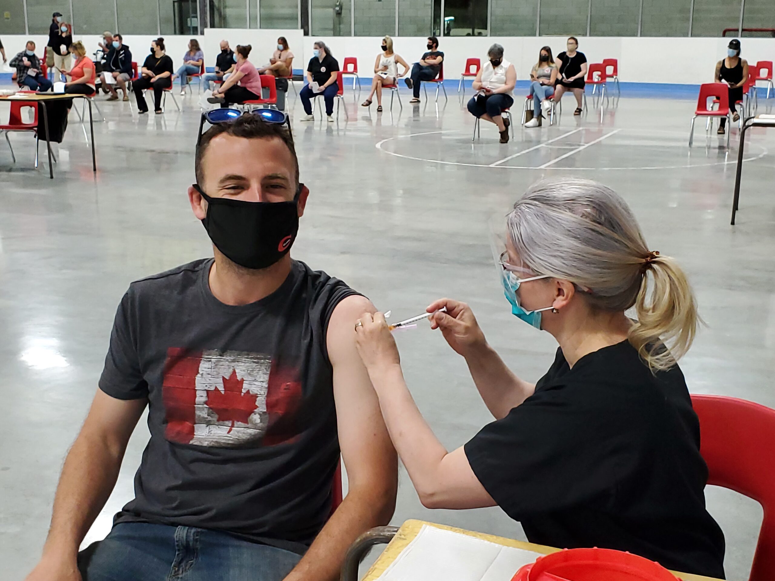 peopleCare Tavistock Director of Care Alena Volkova vaccinating local farmer Jesse McCauley