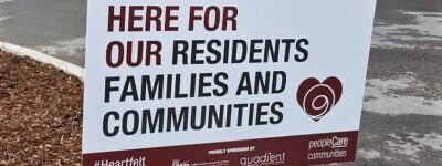 Lawn sign that says here for our residents families and communities