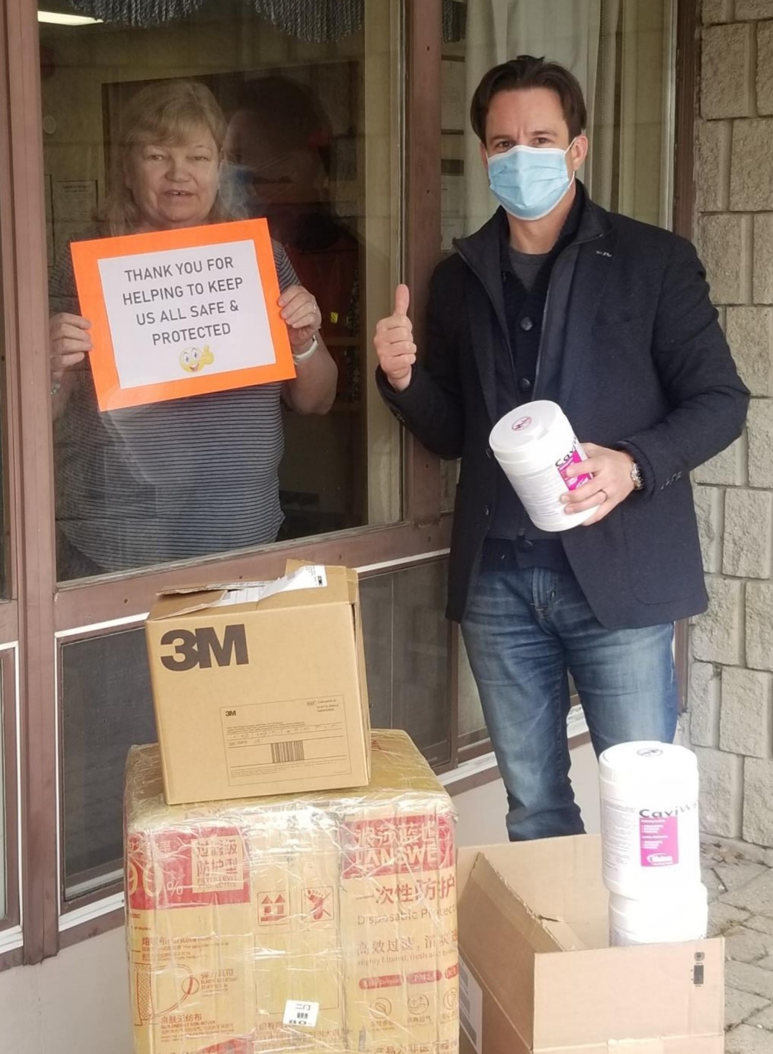 peopleCare CEO drops off PPE and supplies to long-term care home while a resident stands next to the window with a sign