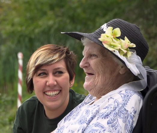 peopleCare staff member and resident smiling while sitting next to a lake