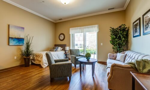 Bed and seating area in studio suite at Oakcrossing Retirement Living