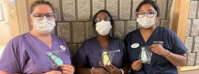 three peopleCare staff members holding cookies