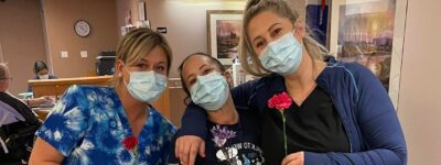 Three peopleCare staff members holding flowers