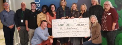 A group of healthcare leaders holding a big donation cheque of $100,000 for MEDA